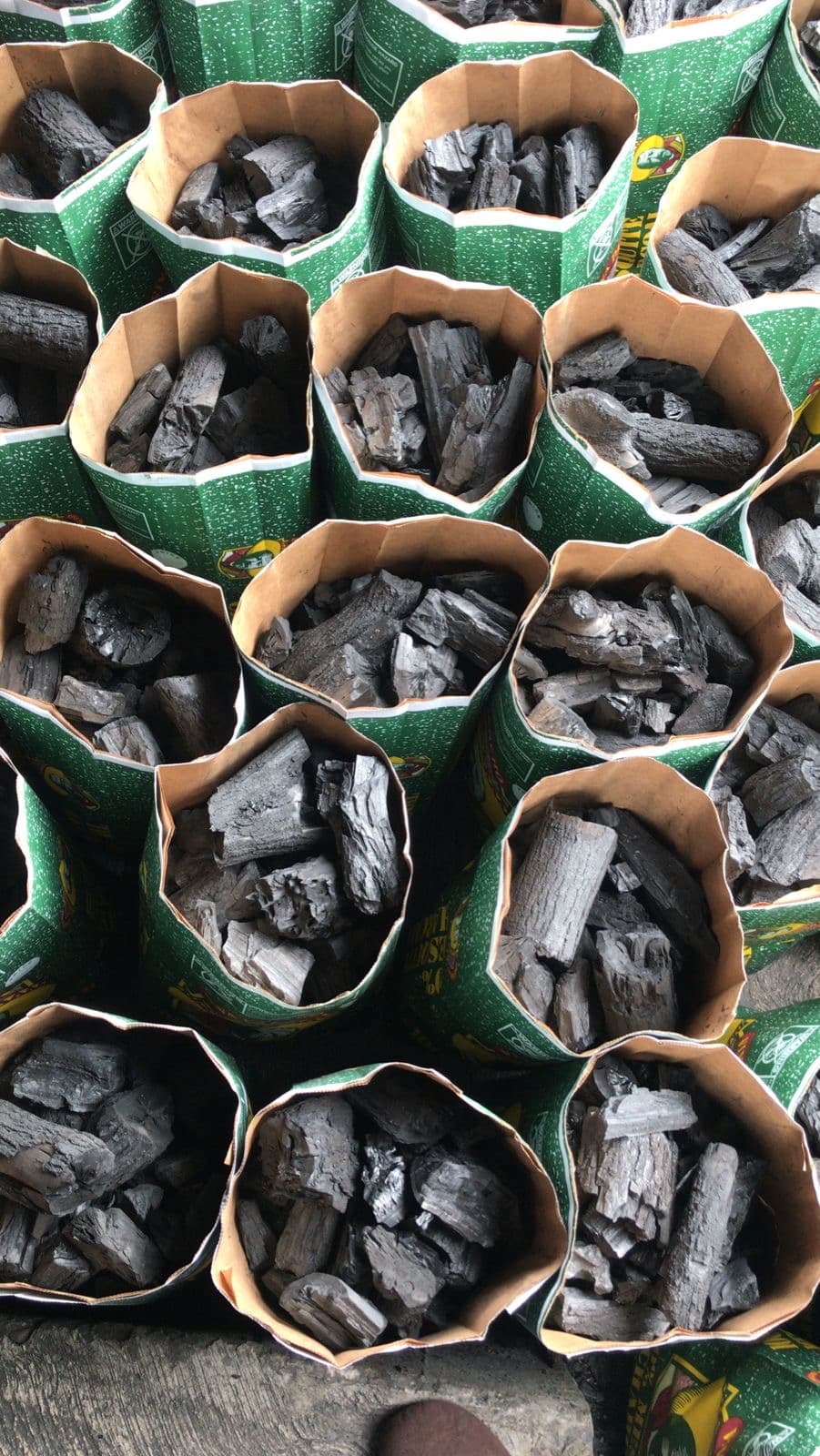 Open bags of Viva Pancho mesquite charcoal being filled